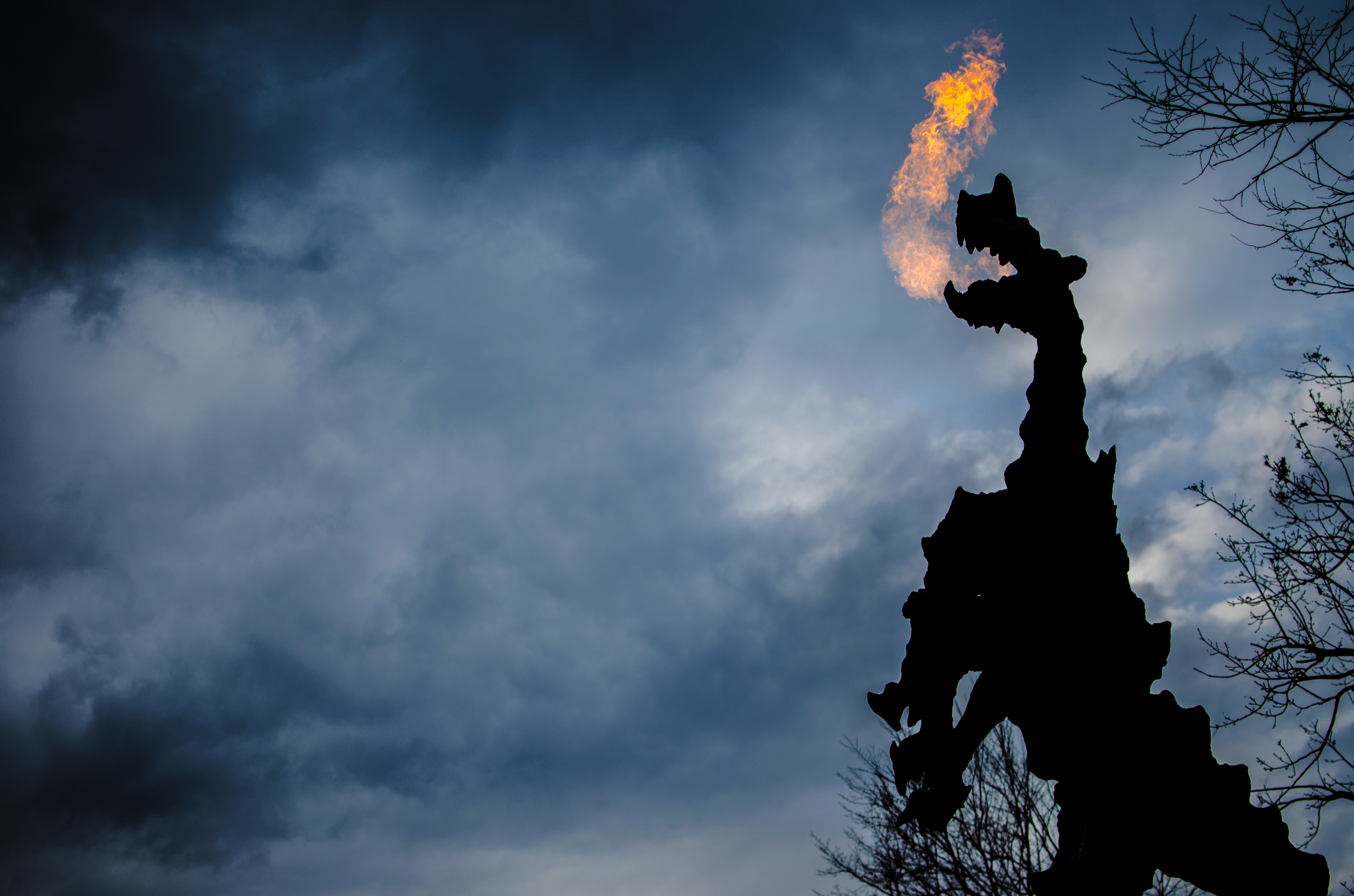 Den berømte Wawel-drage i Krakow der ånder ild mod en dramatisk aftenhimmel - symbolet på byens grundlæggelseslegende om Kong Krak