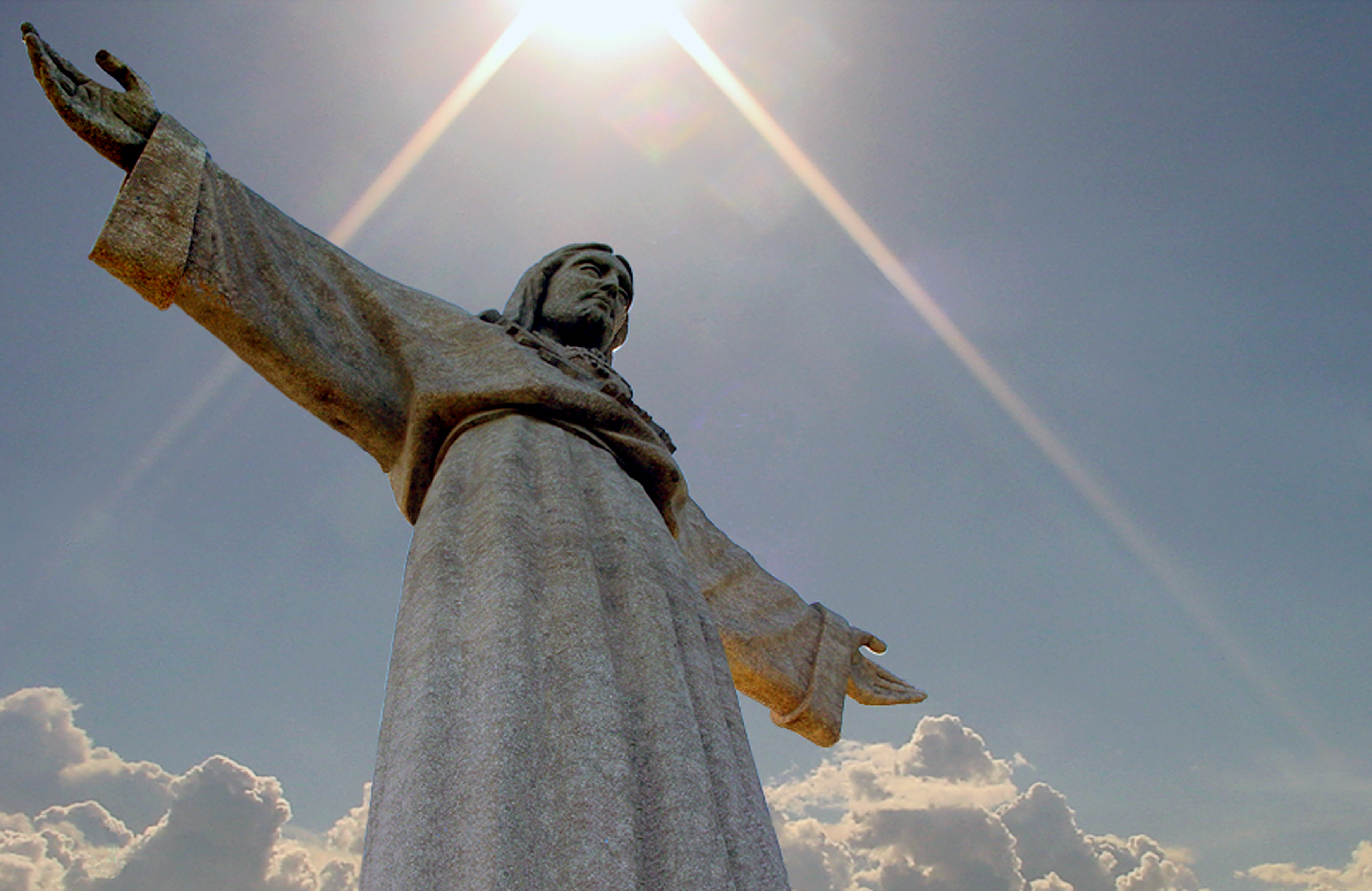Den majestætiske Kristus-statue i Lissabon badet i gyldent sollys med udsigt over Portugals hovedstad