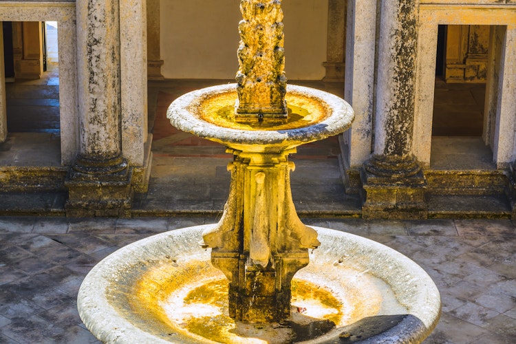 Det historiske Kristusordenen-kloster i Tomar, Portugal, med imponerende middelalderarkitektur under klar blå himmel - et UNESCO verdensarvssted