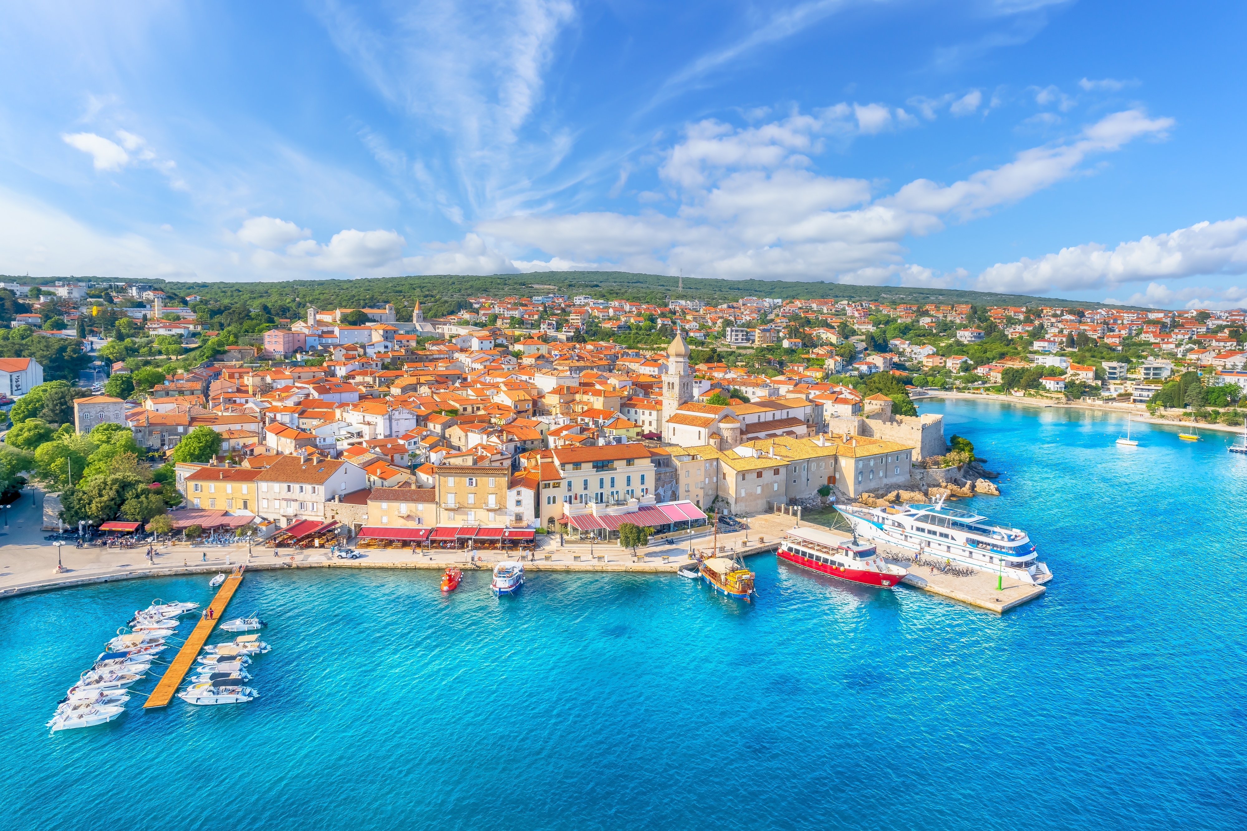 Luftfoto af middelalderlig kroatisk kystby med turkis havn og røde tegltage