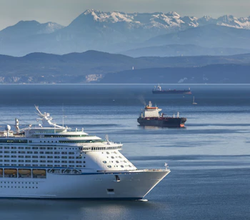 Stort hvidt krydstogtskib ankommer til havnen i Koper, Slovenien med de smukke Juliske Alper i baggrunden og det azurblå hav
