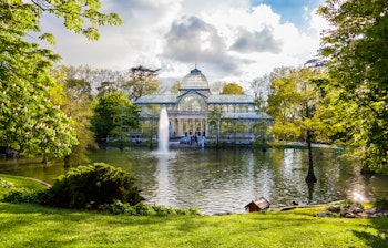 Det historiske Krystalpalads i Retiro Park med spejling i søen, et populært turistmål i Madrid, Spanien