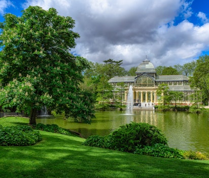 Krystalpaladset i Retiro-parken med spejlbillede i søen, en historisk seværdighed i Madrid, Spanien