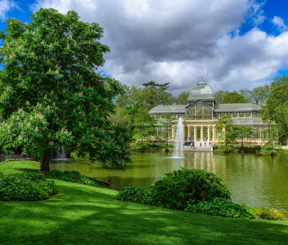 Krystalpaladset i Retiro-parken med spejlbillede i søen, en historisk seværdighed i Madrid, Spanien