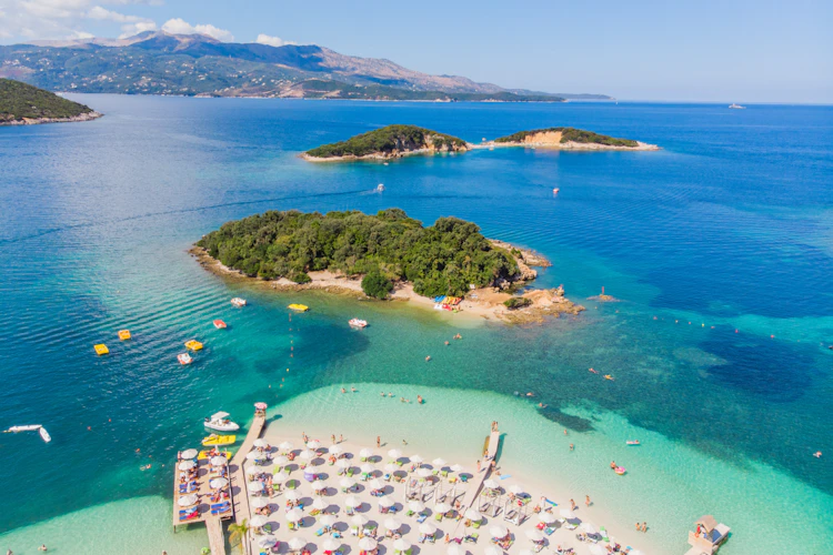 Luftfoto af Ksamil strand i Albanien med turkisblåt vand og små øer - perfekt feriemål ved Middelhavet