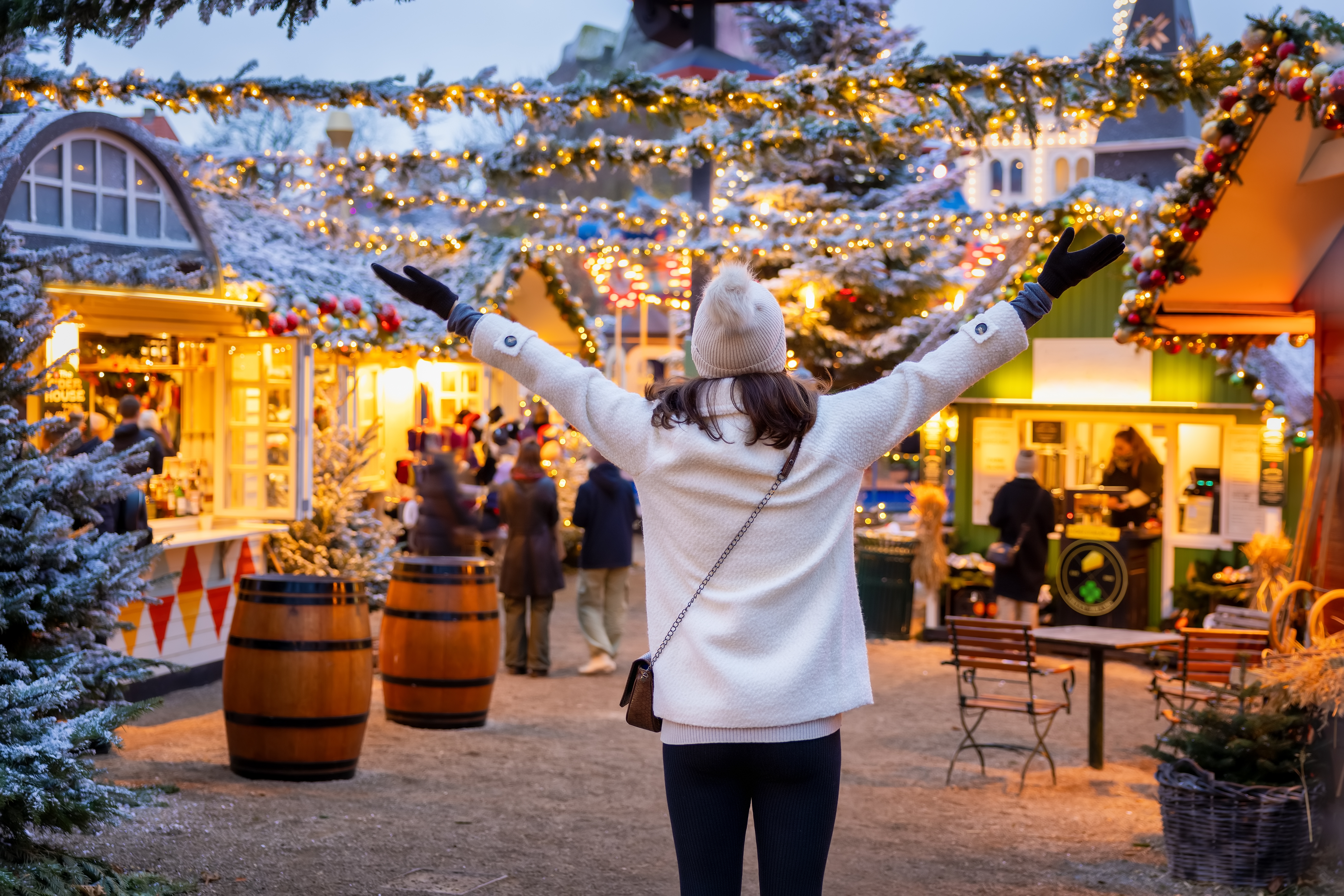 Glad kvinde på julemarked i København med sne og julelys