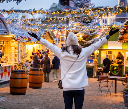 Glad kvinde på julemarked i København med sne og julelys