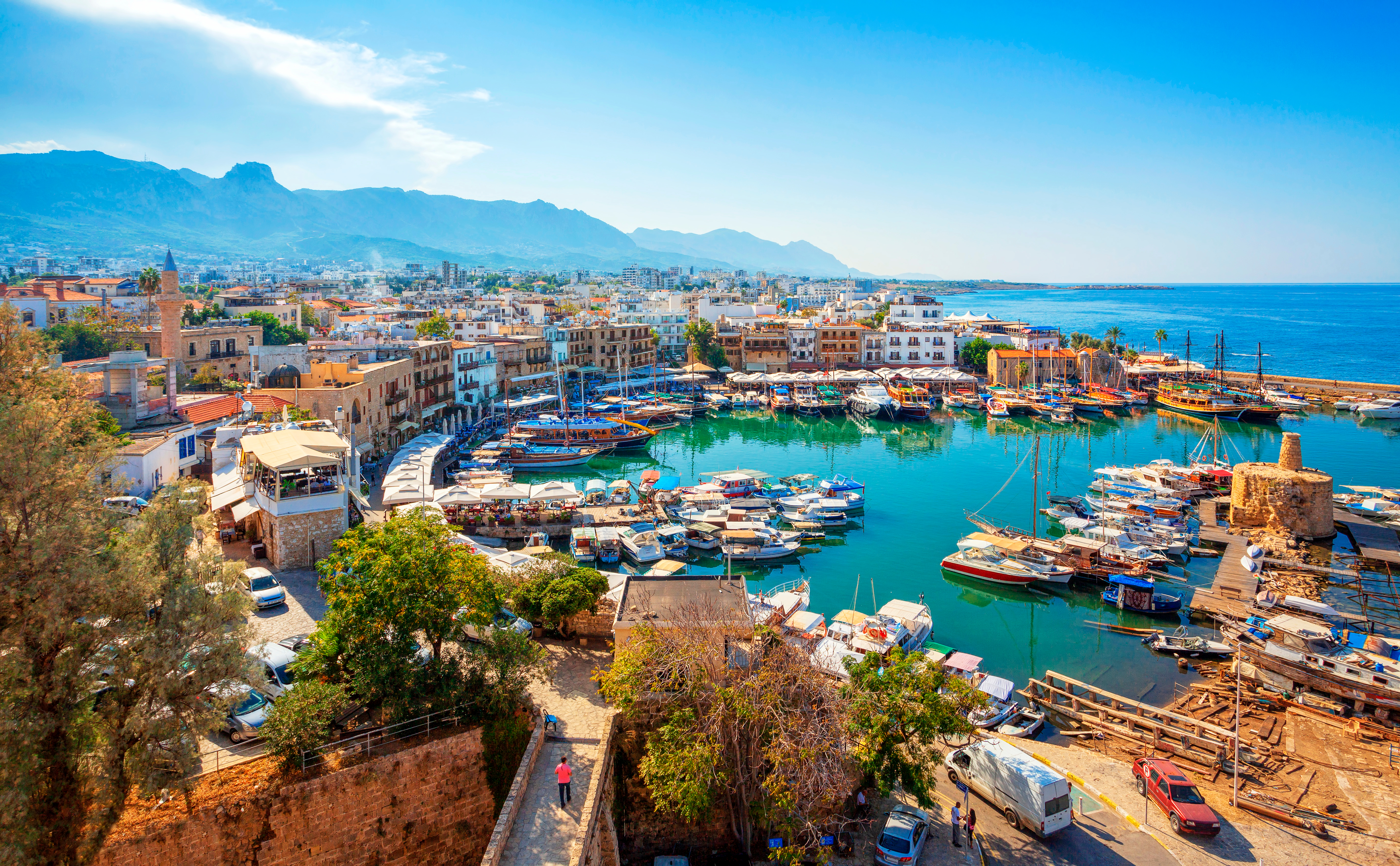 Smuk panoramaudsigt over Kyrenia havn på Nord-Cypern med både og historiske bygninger langs Middelhavets kystlinje