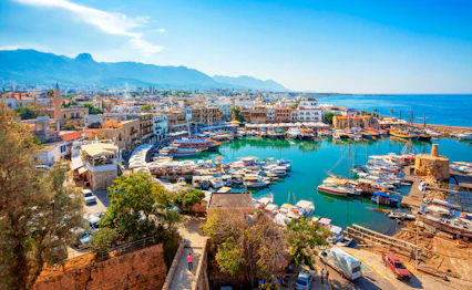 Smuk panoramaudsigt over Kyrenia havn på Nord-Cypern med både og historiske bygninger langs Middelhavets kystlinje