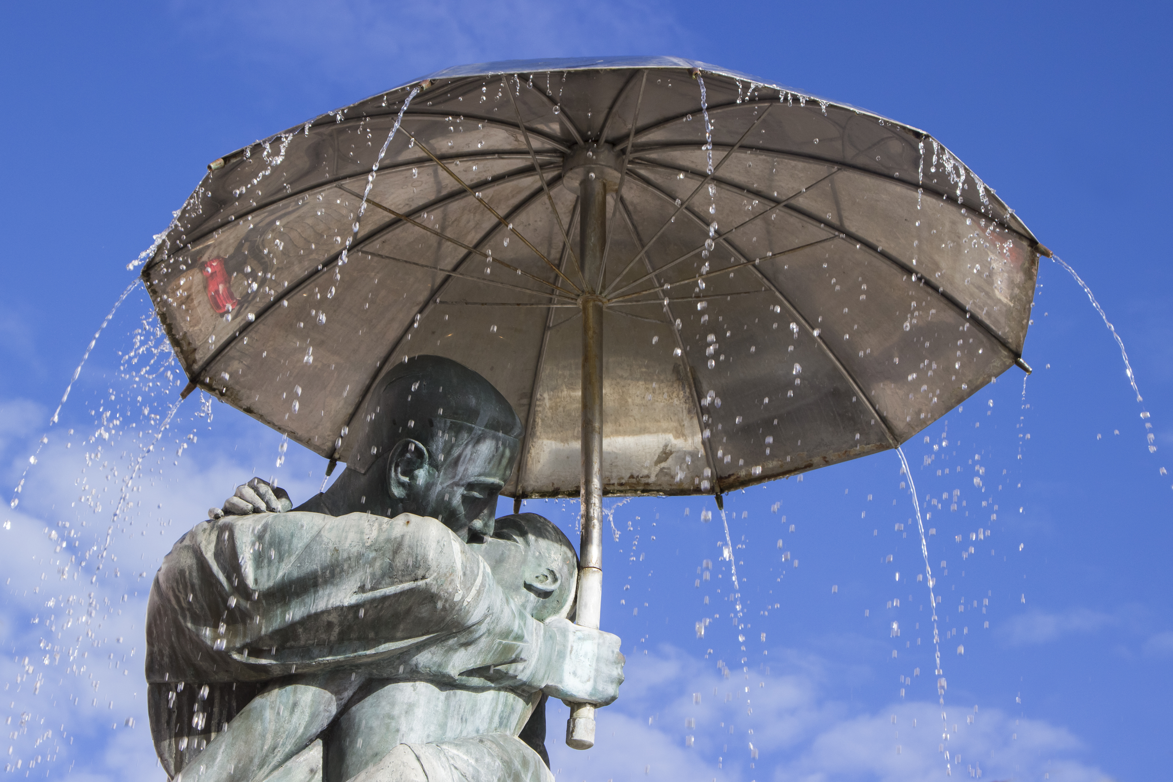 Den berømte statue "Kyssende Studerende" med paraplyer foran rådhuset i Tartu, Estland - et romantisk vartegn i byens centrum