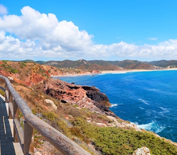 Træbelagt kyststi langs Costa Vicentina i vestlige Algarve, Portugal, med panoramaudsigt over Atlanterhavet og de stejle sandstensklipper