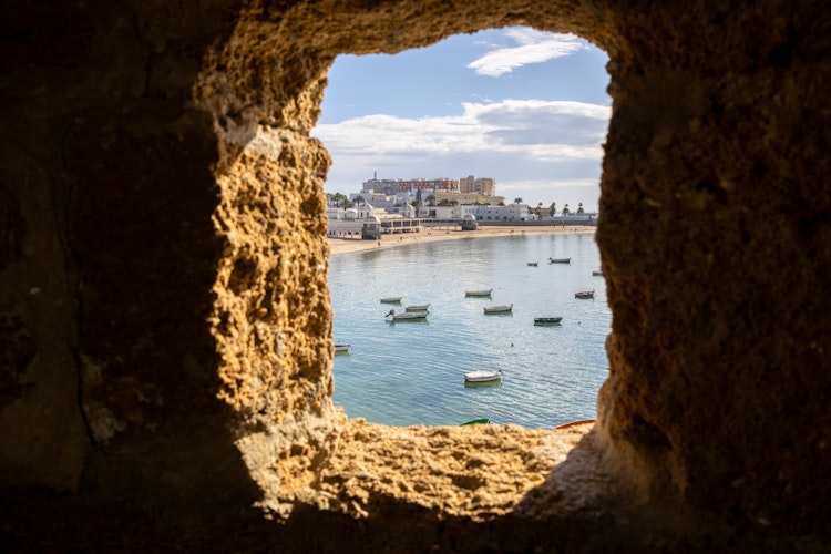 Betagende panoramaudsigt over det historiske badehus Balneario Nuestra Señora de la Palma på La Caleta-stranden i Cádiz, fotograferet fra Santa Catalina-borgen med det blå Atlanterhav i baggrunden - oplev Andalusiens smukke kystlinje
