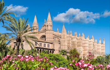 Den gotiske La Seu katedral i Palma de Mallorca med blomstrende oleander i forgrunden, et historisk vartegn på Mallorca i Spanien