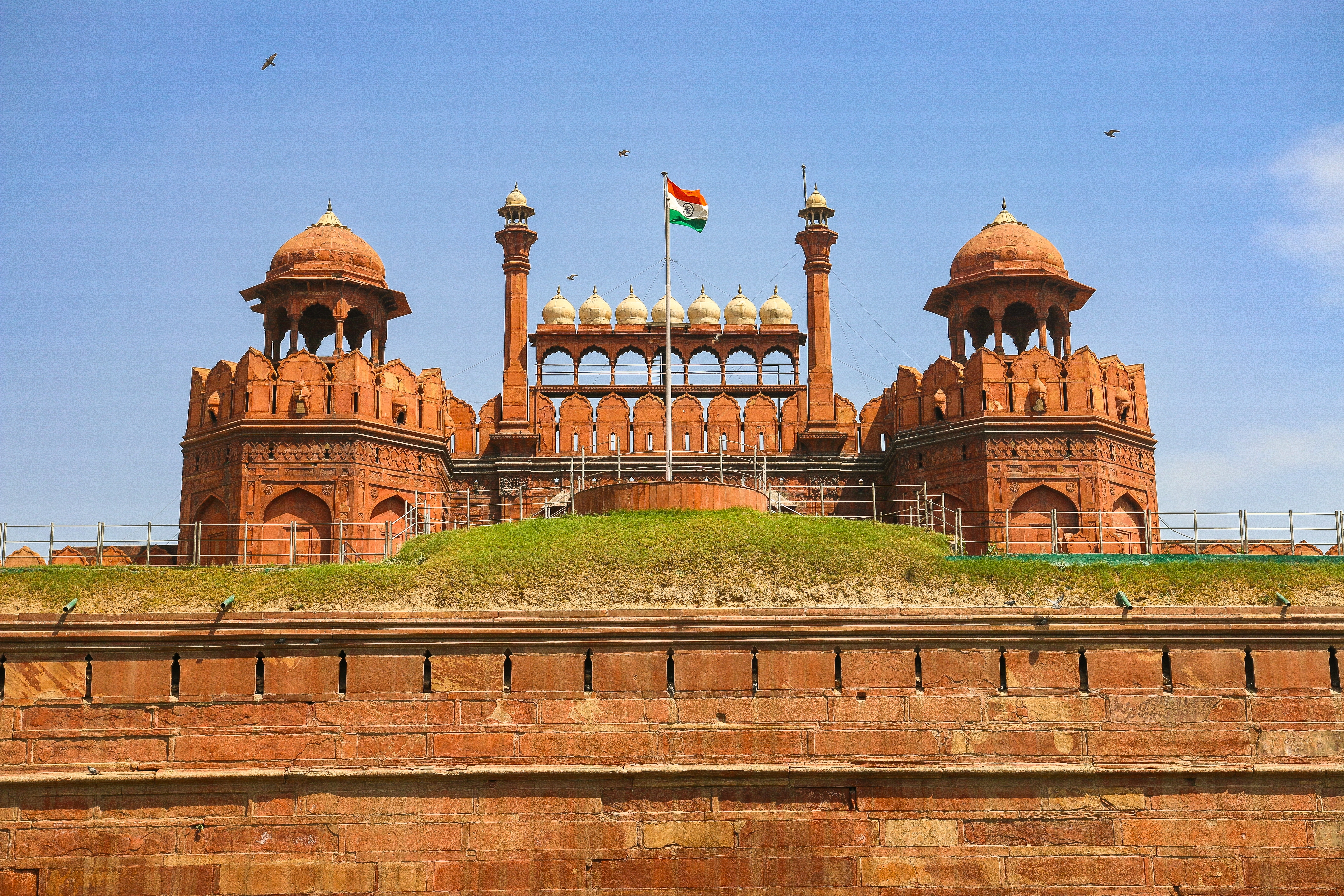 Den imponerende øvre bastion af Lahori Gate ved Delhis Røde Fort med det indiske flag vajende mod den blå himmel
