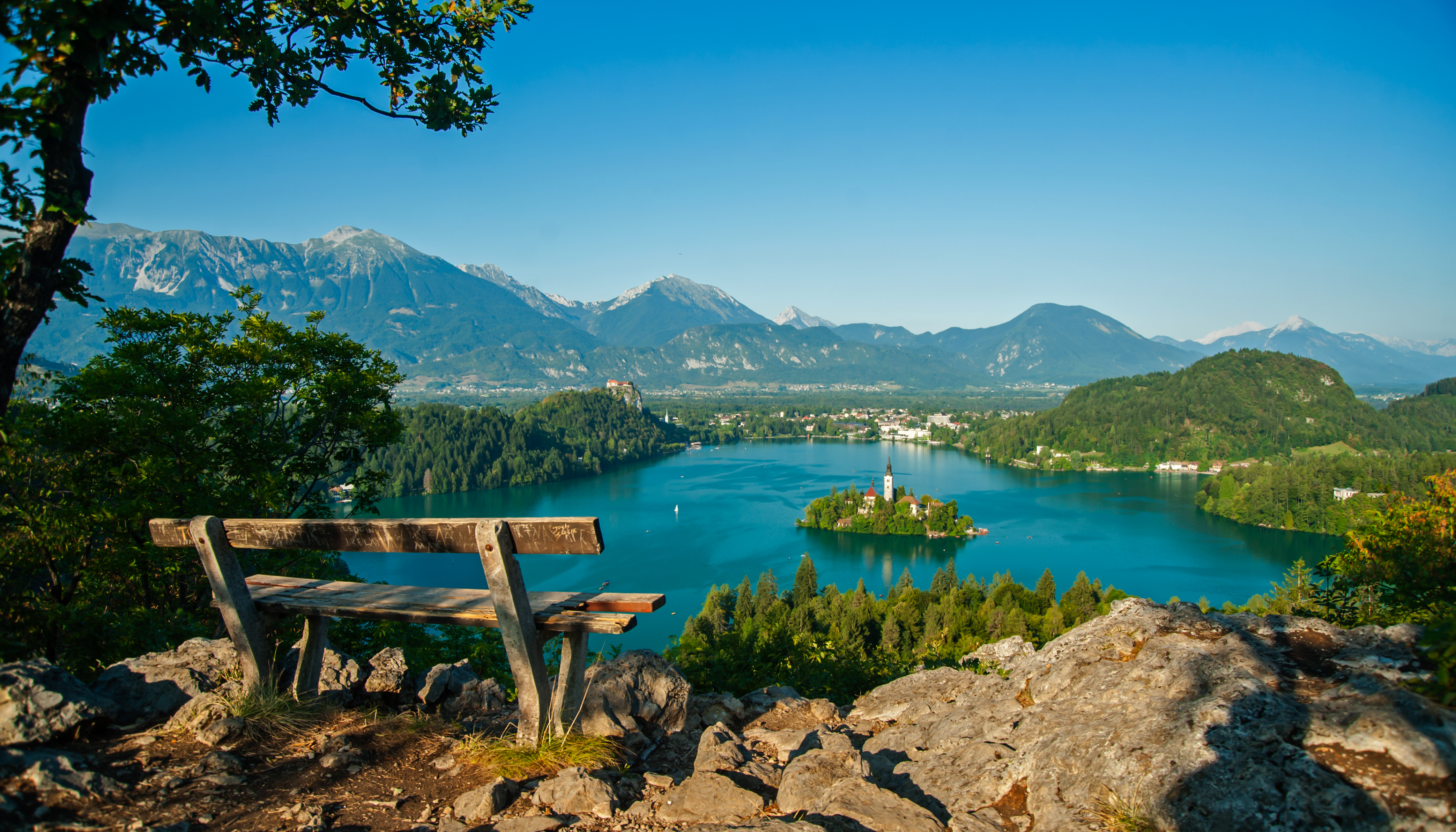 Betagende panoramaudsigt over Bled-søen fra Ojstrica-bjerget med den ikoniske ø, slot og Alperne i Slovenien
