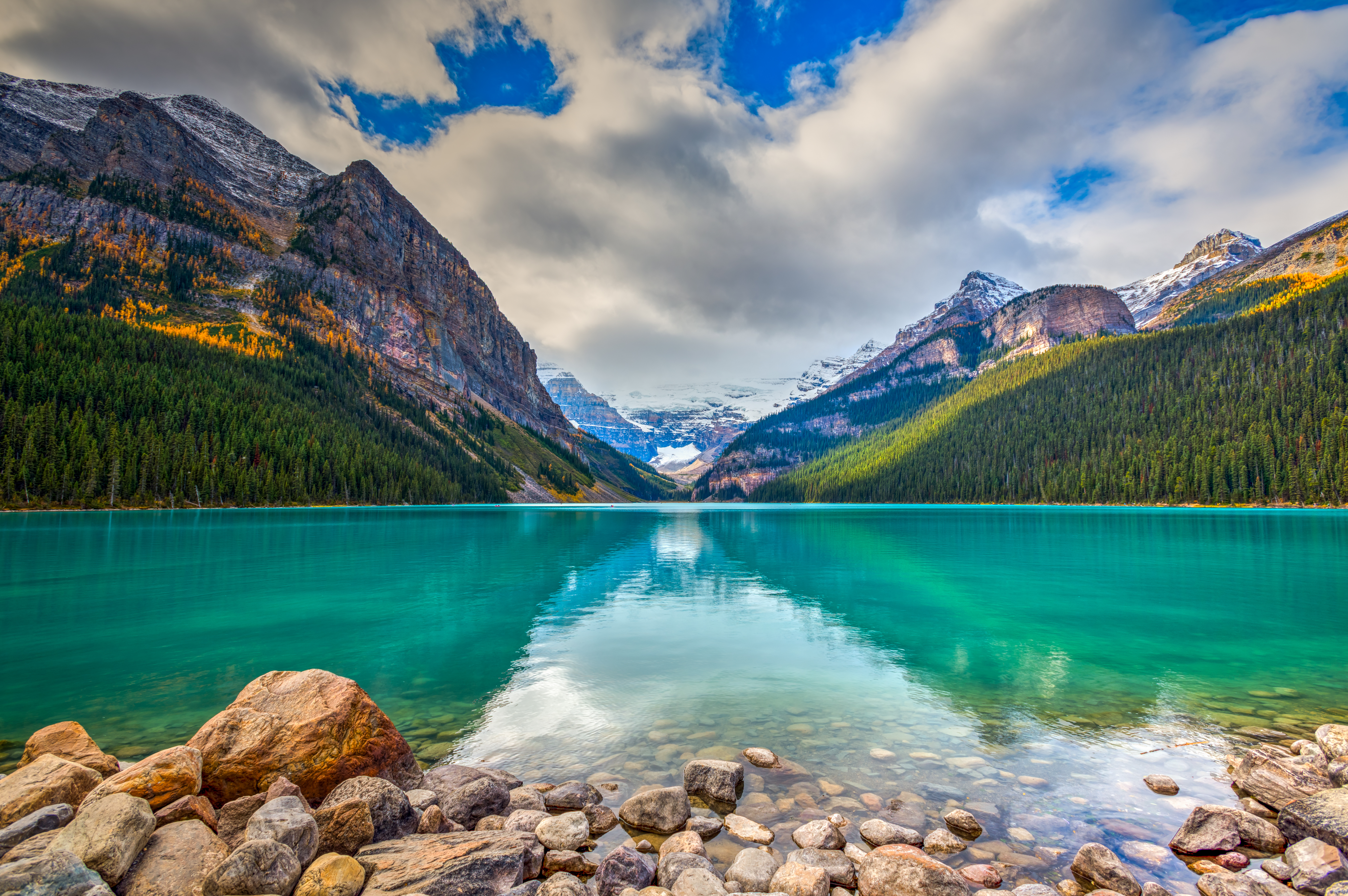 Smukke Lake Louise med turkisblåt vand og spejling af sneklædte Rocky Mountains i Banff Nationalpark, Canada om efteråret