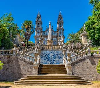 Imponerende barok trappe med udsmykkede balustrader og azulejo-fliser der fører til Vor Frue kirken på bakketoppen i Lamego, Portugal
