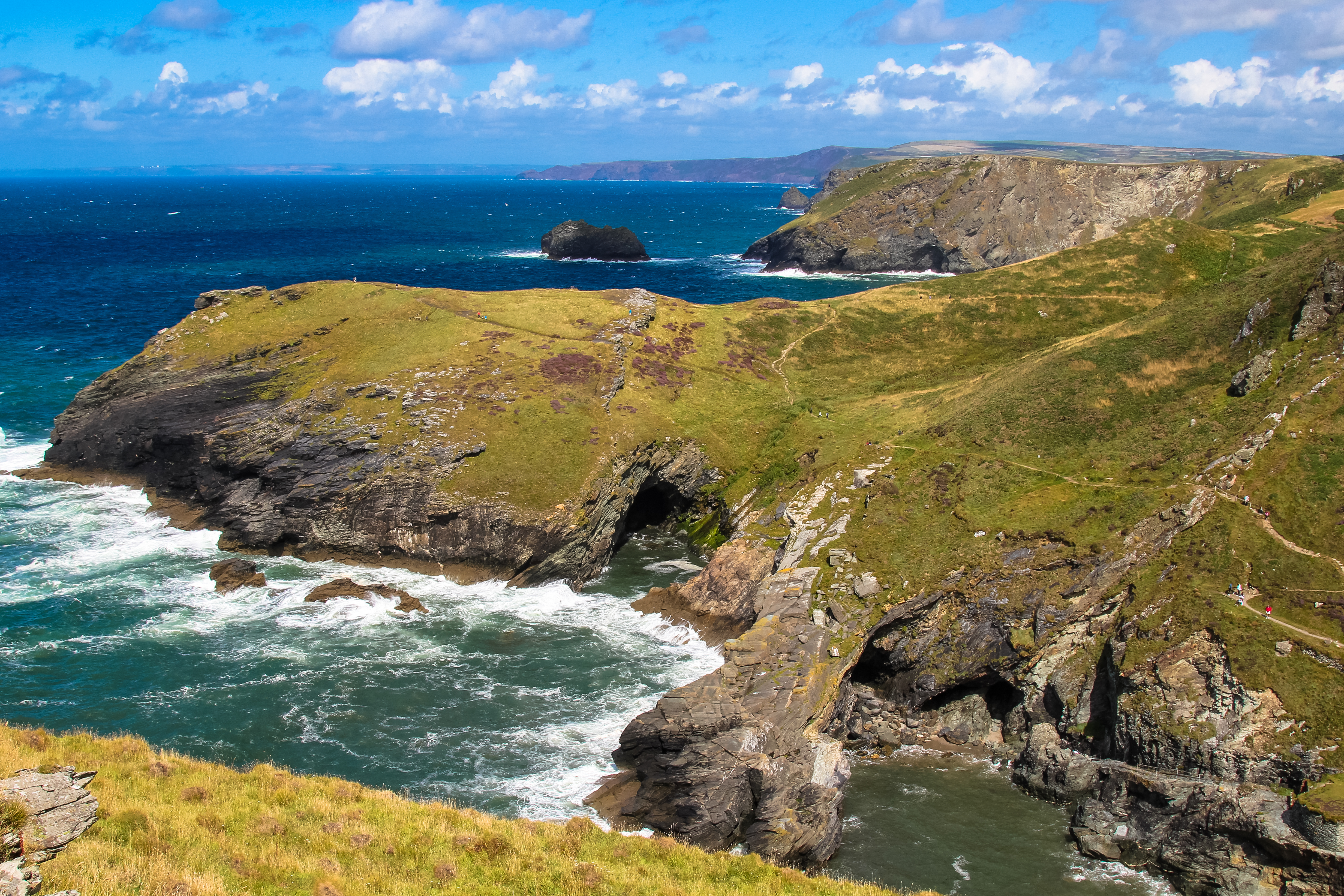 Spektakulær udsigt over klipperne ved Land's End i Cornwall, England, med Atlanterhavet og en dramatisk himmel i baggrunden