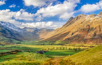 Betagende udsigt over Langdale Pikes med grønne dale og dramatisk himmel i Lake District, England - perfekt destination for naturelskere