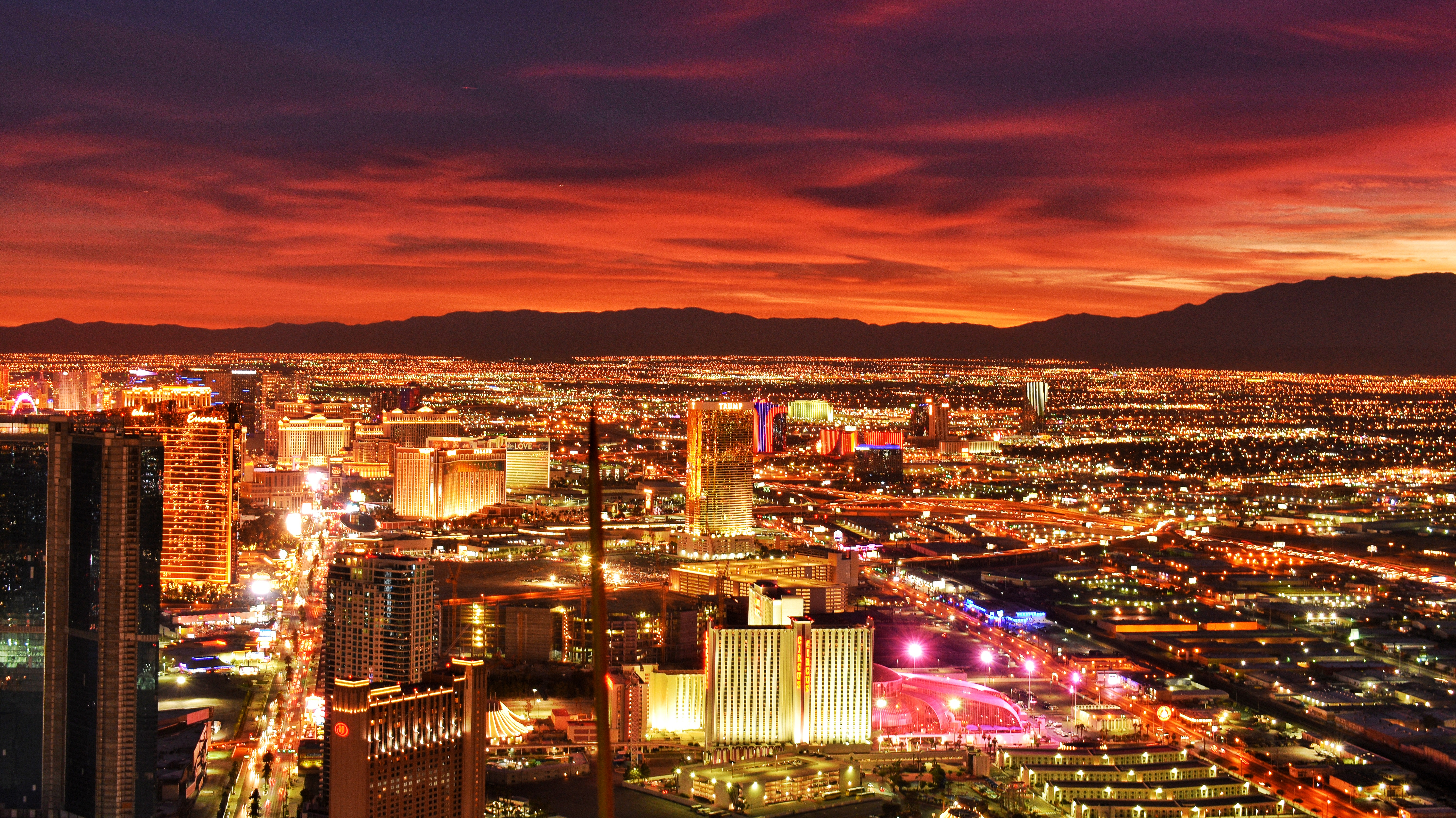 Las Vegas Strip skyline ved solnedgang med dramatisk rød himmel og bylys over ørkendalen