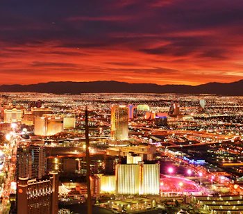 Las Vegas Strip skyline ved solnedgang med dramatisk rød himmel og bylys over ørkendalen