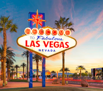 Berømte Welcome to Las Vegas skilt ved solnedgang med palmer