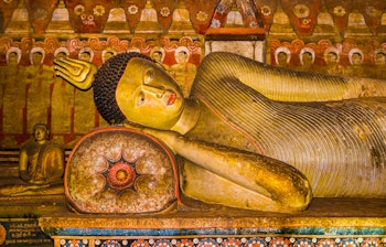 Imponerende liggende Buddha-statue i det ældgamle Dambulla grottetempel i Sri Lanka - et UNESCO verdensarvssted med bemærkelsesværdig buddhistisk kunst og kulturhistorie