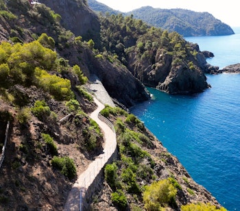 Malerisk kyststi langs Middelhavets klipper i Liguria Italien med turkisblaat vand
