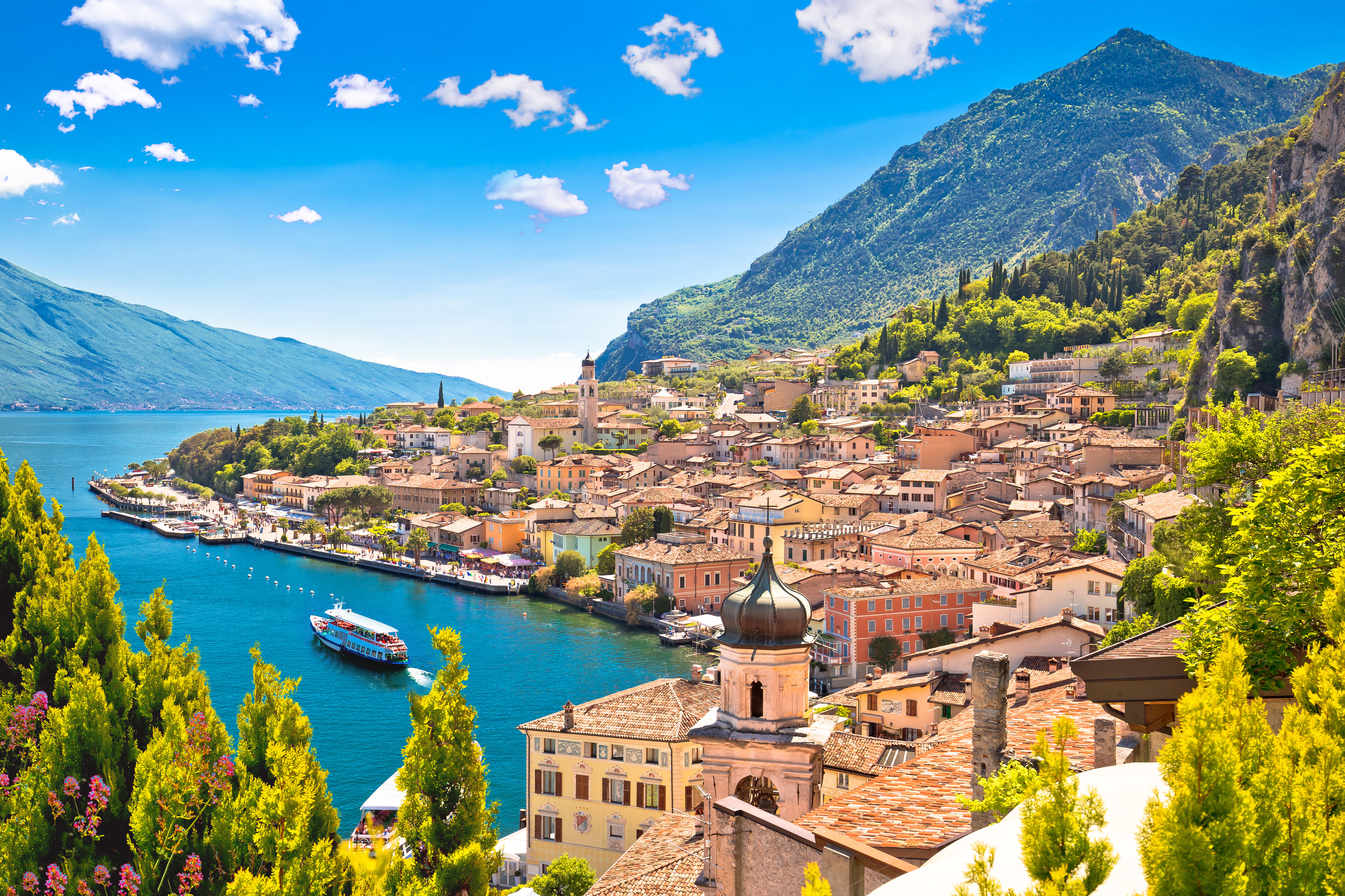 Smukt panoramaudsigt over Limone sul Garda med turkisblåt vand, farverige bygninger og grønne bjerge ved Gardasøen i Lombardiet, Italien