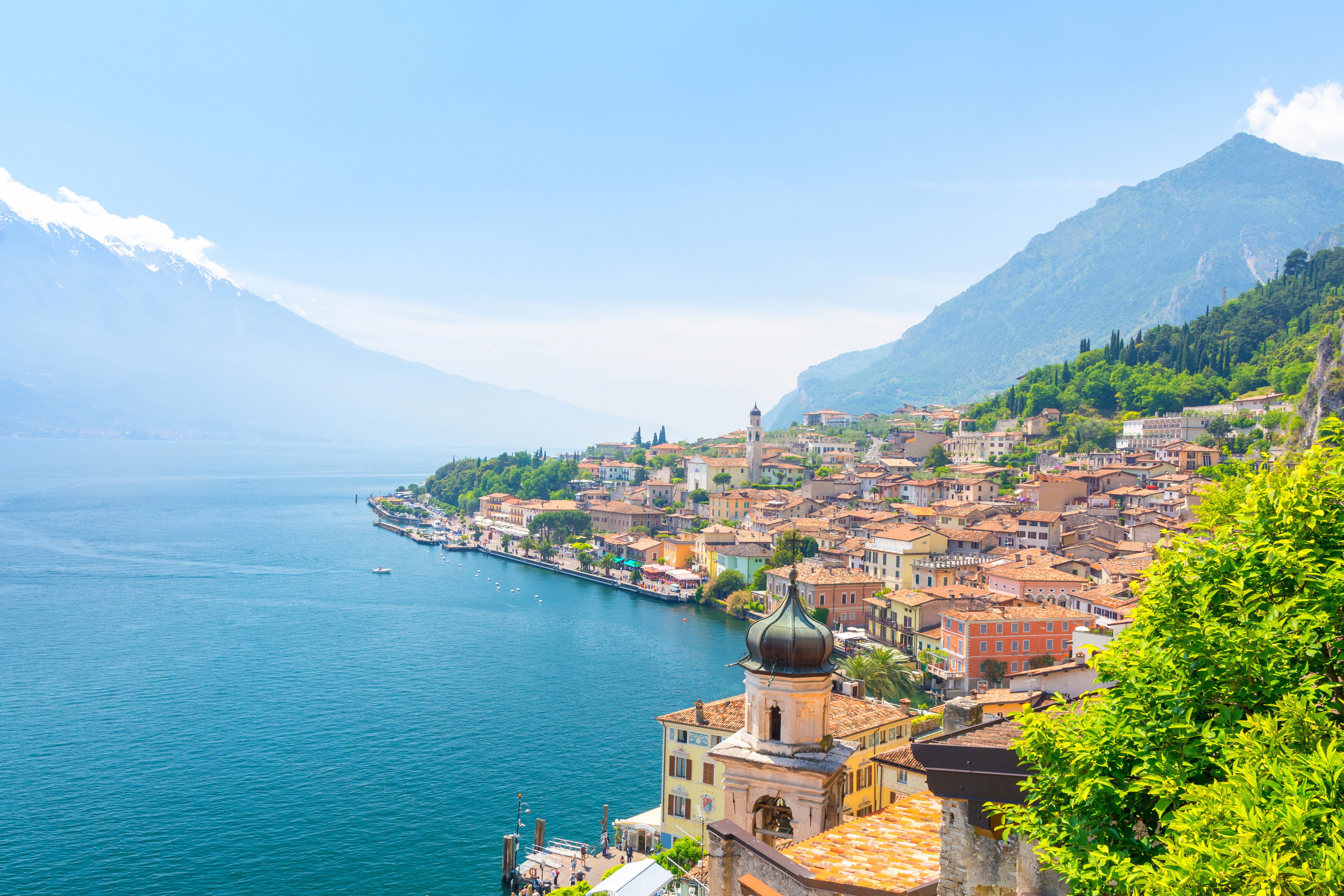 Panoramaudsigt over den smukke italienske by Limone sul Garda ved Gardasøen med terrakottafarvet hustage og alpine bjerge i baggrunden
