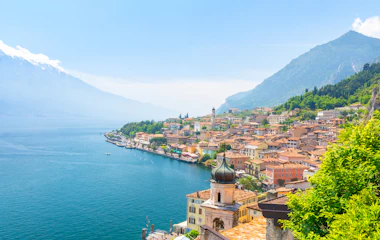 Panoramaudsigt over den smukke italienske by Limone sul Garda ved Gardasøen med terrakottafarvet hustage og alpine bjerge i baggrunden