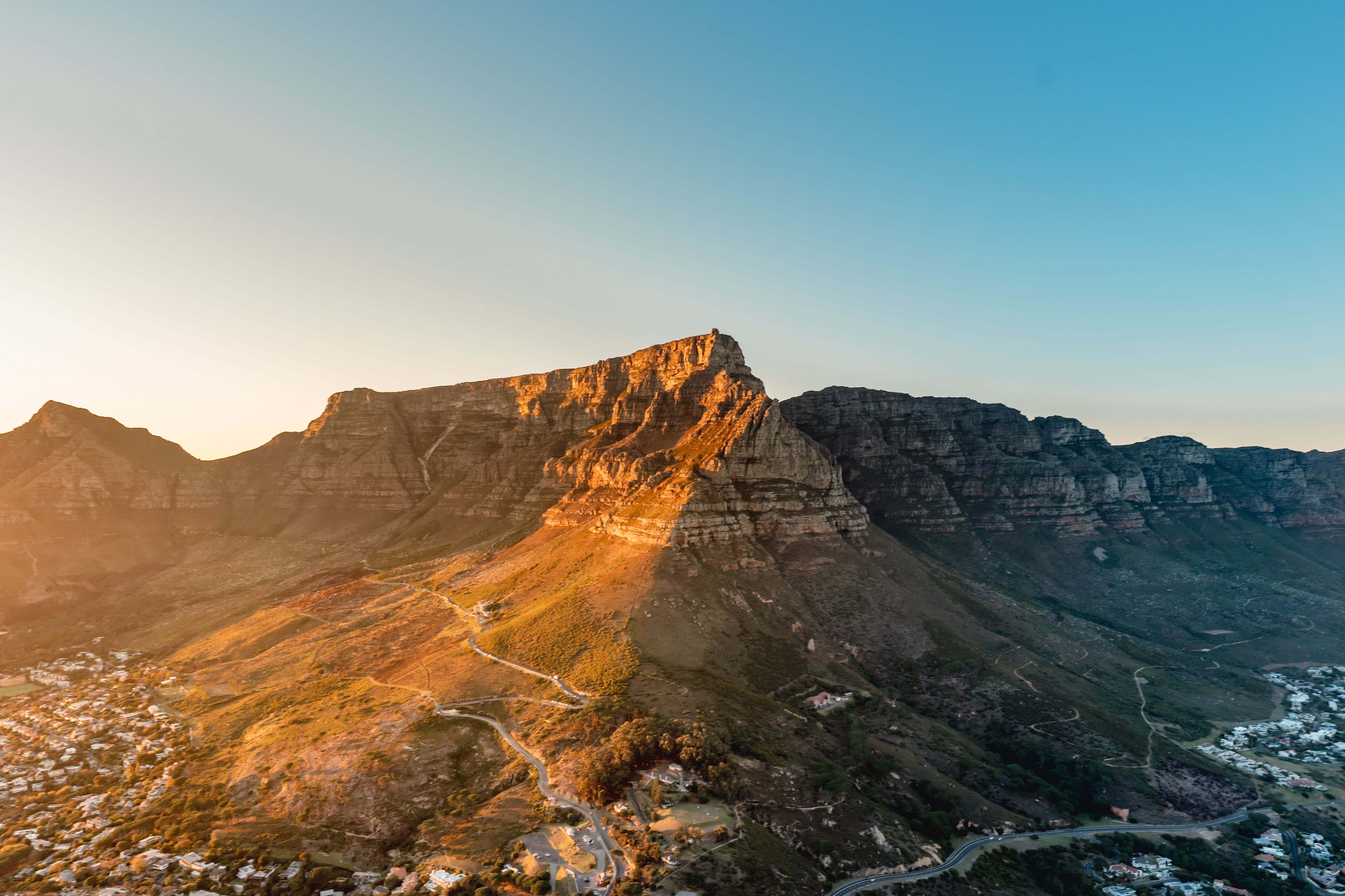 Spektakulær udsigt fra Lion's Head ved solopgang med Table Mountain, Cape Town centrum og den smukke Camps Bay kystlinje badet i gyldent morgenlys - oplev Sydafrikas betagende landskaber med Smil Rejser
