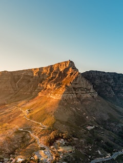 Spektakulær udsigt fra Lion's Head ved solopgang med Table Mountain, Cape Town centrum og den smukke Camps Bay kystlinje badet i gyldent morgenlys - oplev Sydafrikas betagende landskaber med Smil Rejser