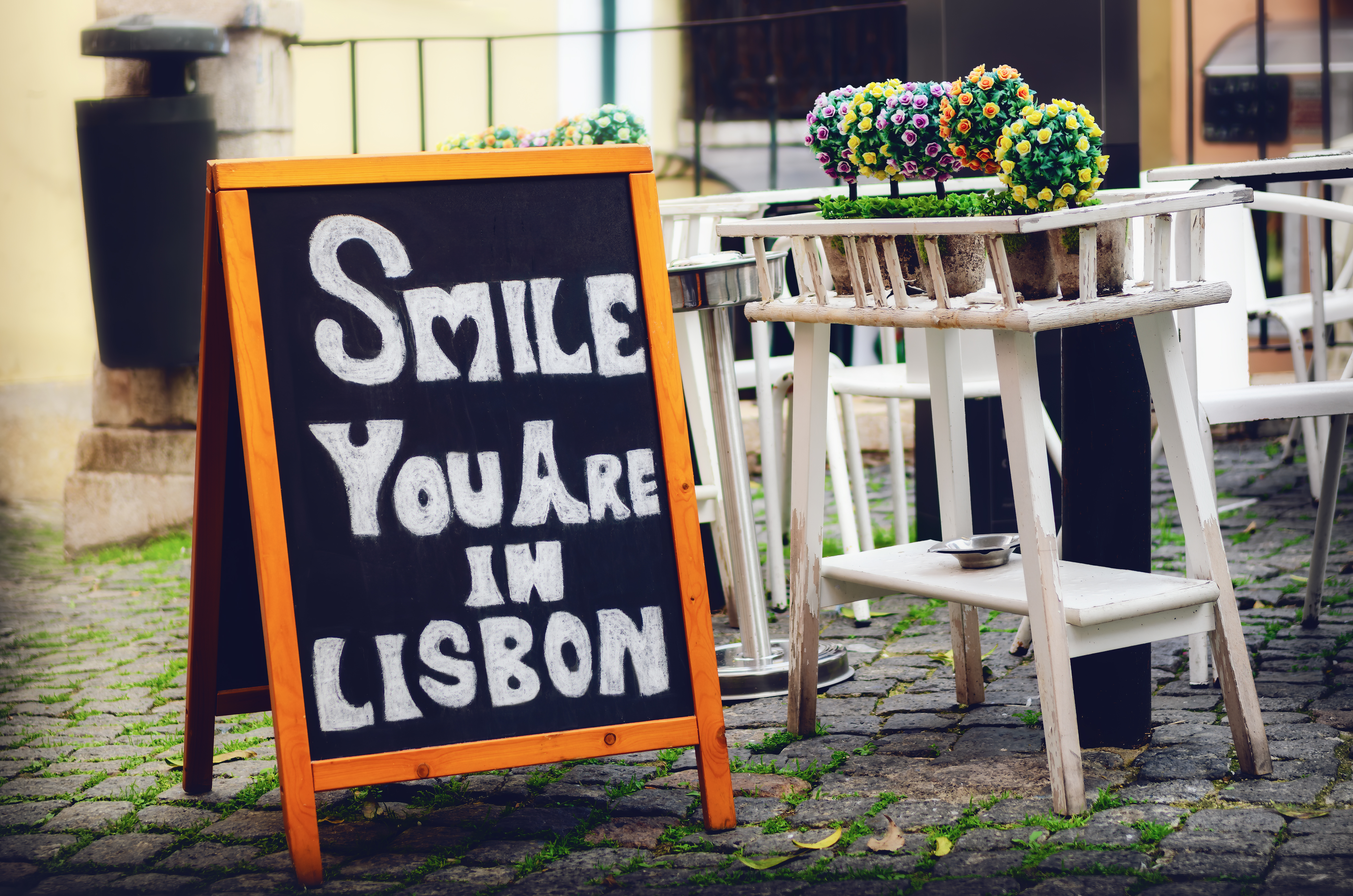 Charmerende sort tavle med teksten "Smile you are in Lisbon" i det historiske Alfama-kvarter i Lissabon, kendt for traditionelle restauranter og fado-musik