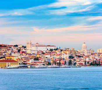 Smukt udsigt over Lissabons farverige havnefront med historiske bygninger ved Tagus-floden
