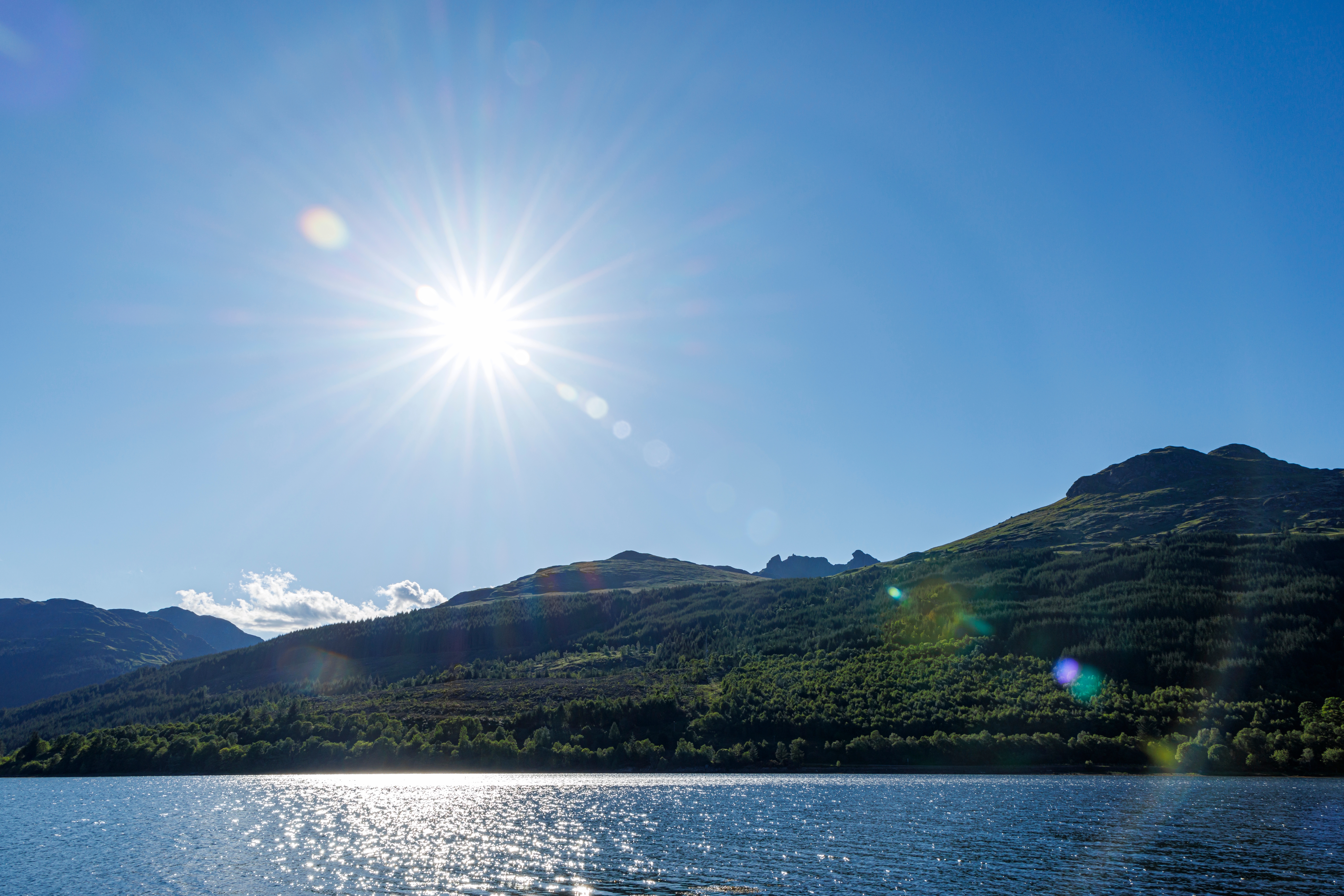 Skotsk sø Loch Long med bjerge og solskin i Trossachs Nationalpark