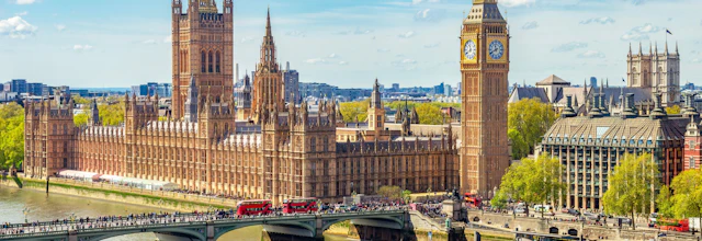 London byudsigt med Big Ben klokketårn og Westminster Bridge over Themsen med røde busser