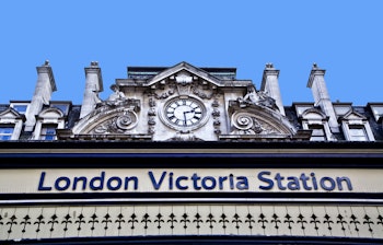 Victoria Station i London med det ikoniske blå skilt på den historiske bygningsfacade, et centralt knudepunkt for tog- og bustransport i det britiske hovedstadsområde