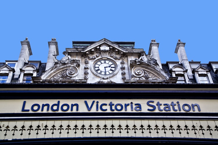 Victoria Station i London med det ikoniske blå skilt på den historiske bygningsfacade, et centralt knudepunkt for tog- og bustransport i det britiske hovedstadsområde