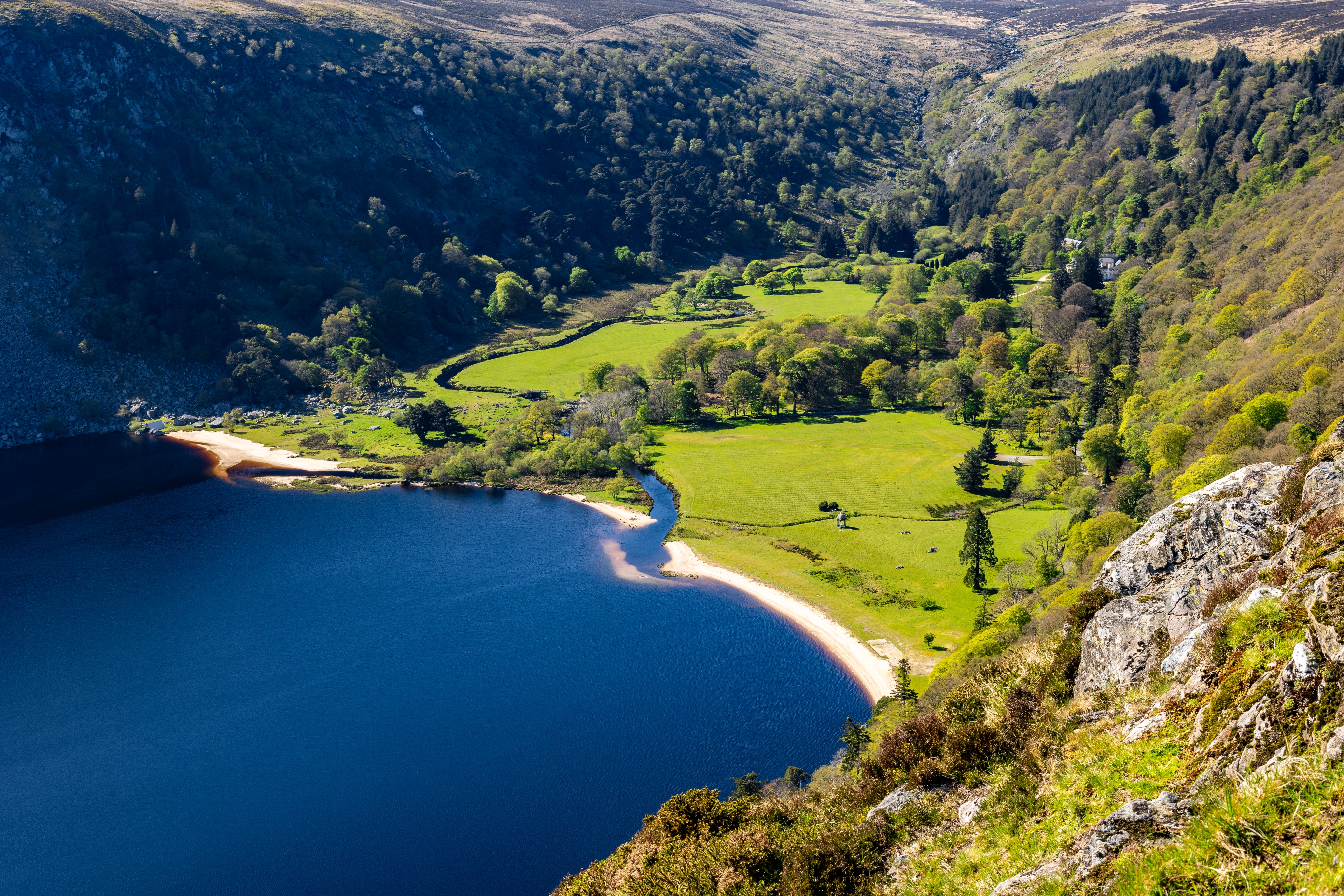 Luftudsigt over den smukke Lough Tay sø omgivet af grønne dale og bjerge i Wicklow Mountains Nationalpark, Irland