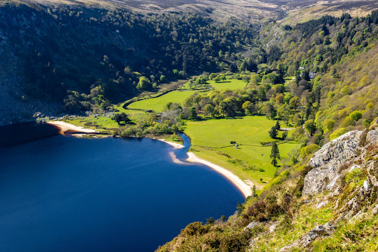 Luftudsigt over den smukke Lough Tay sø omgivet af grønne dale og bjerge i Wicklow Mountains Nationalpark, Irland
