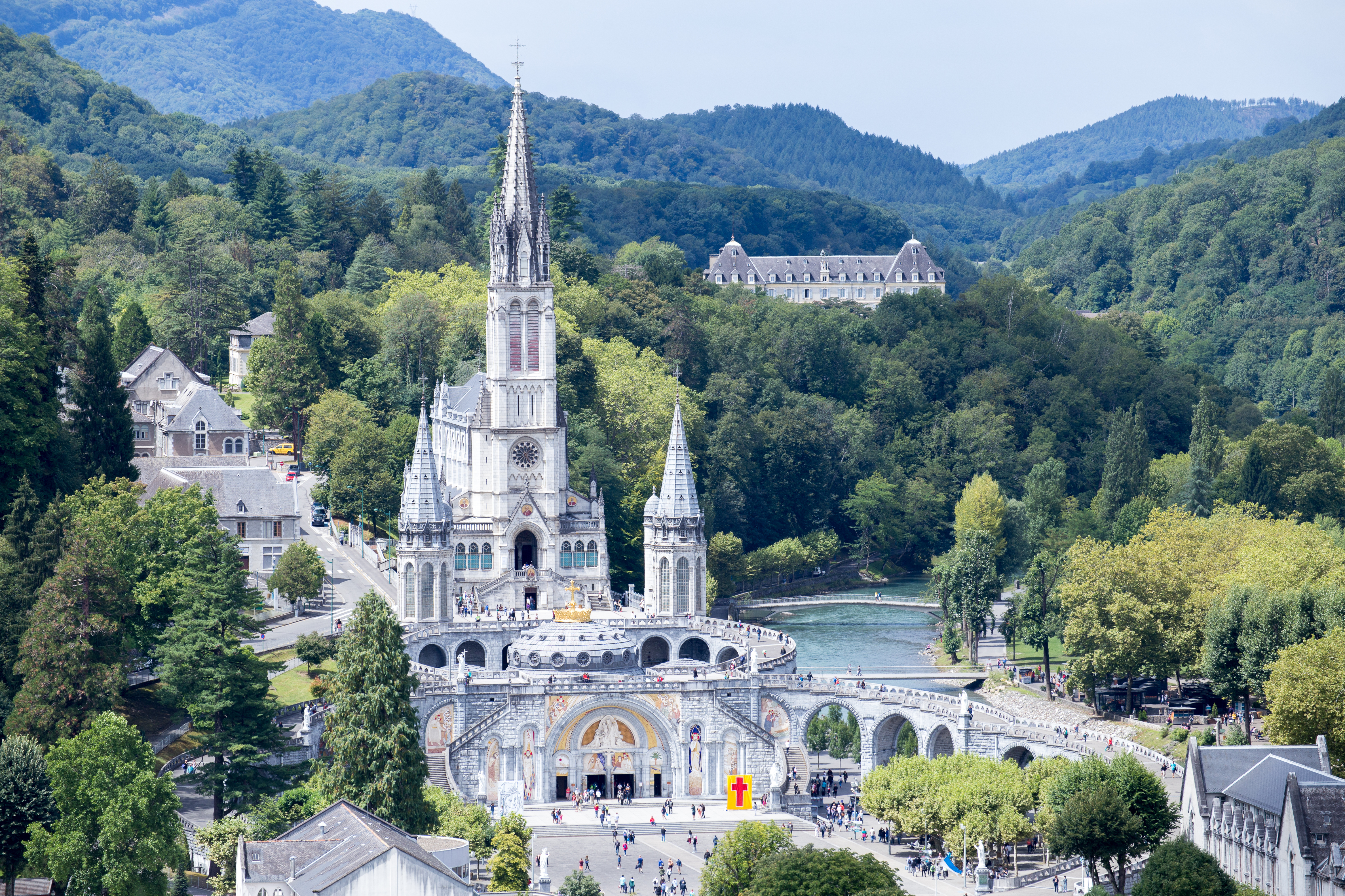 Helligdommen i Lourdes med den hvide basilika omgivet af Pyrenæerne, et berømt pilgrimsmål i Sydfrankrig