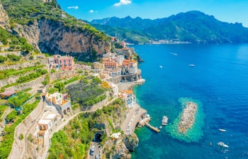 Betagende luftfoto af den charmerende by Atrani på Amalfikysten i Italien, med farverige bygninger på klipperne og det azurblå Middelhav