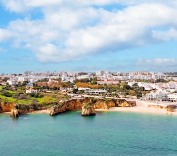 Betagende luftfoto af Lagos i Algarve, Portugal, med historisk bymidte, gyldne sandstrande og det azurblå Atlanterhav