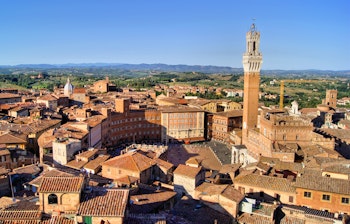 Smukt luftfoto over middelalderbyens Siena i Toscana med den ikoniske Piazza del Campo omgivet af historiske bygninger med røde tage
