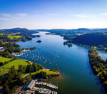 Betagende luftfoto af Windermere-søen omgivet af grønne bjerge i Lake District Nationalpark, England