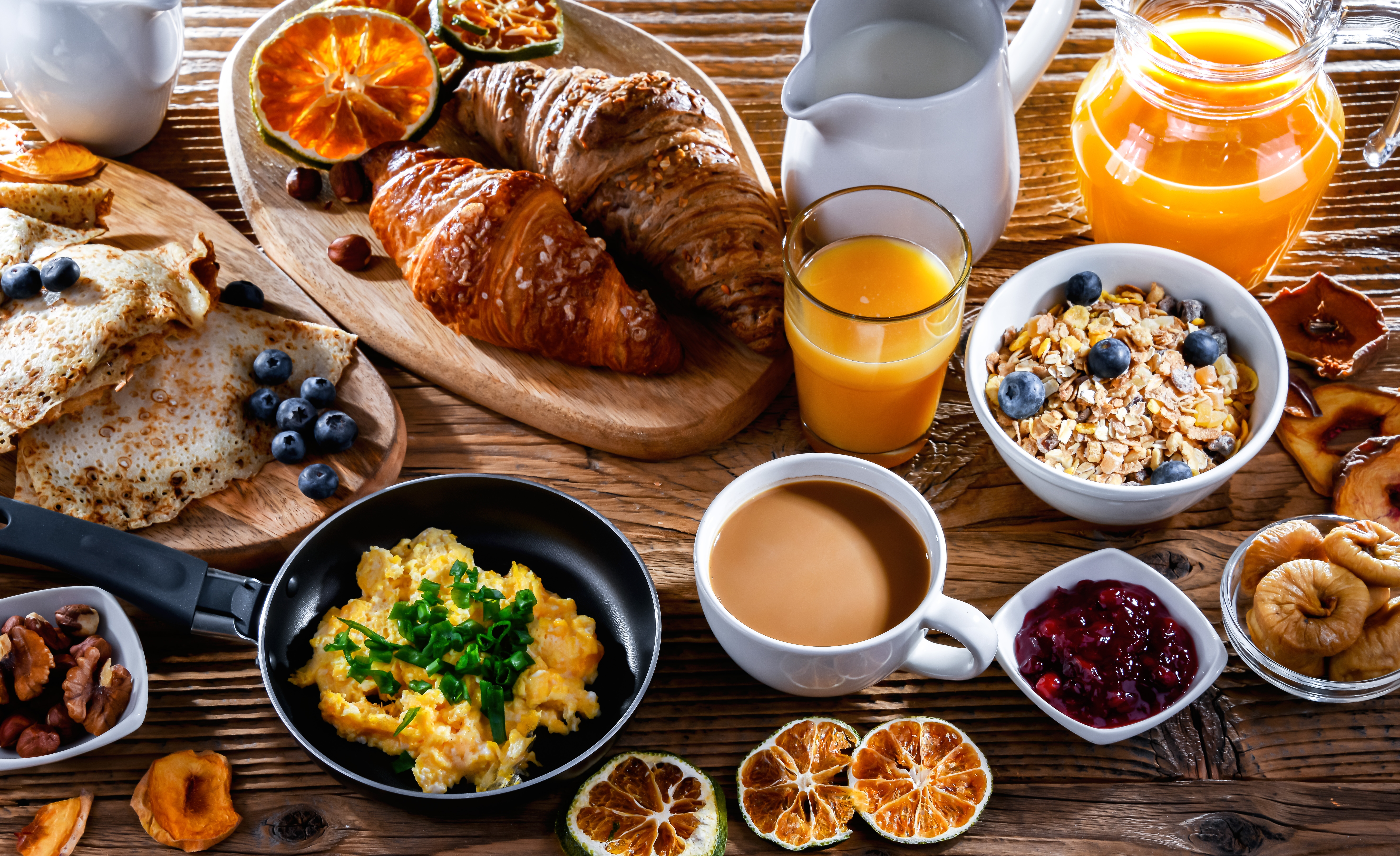 Luksuriøs morgenmadsbuffet med friske croissanter, røræg, kaffe og appelsinjuice på dansk hotel