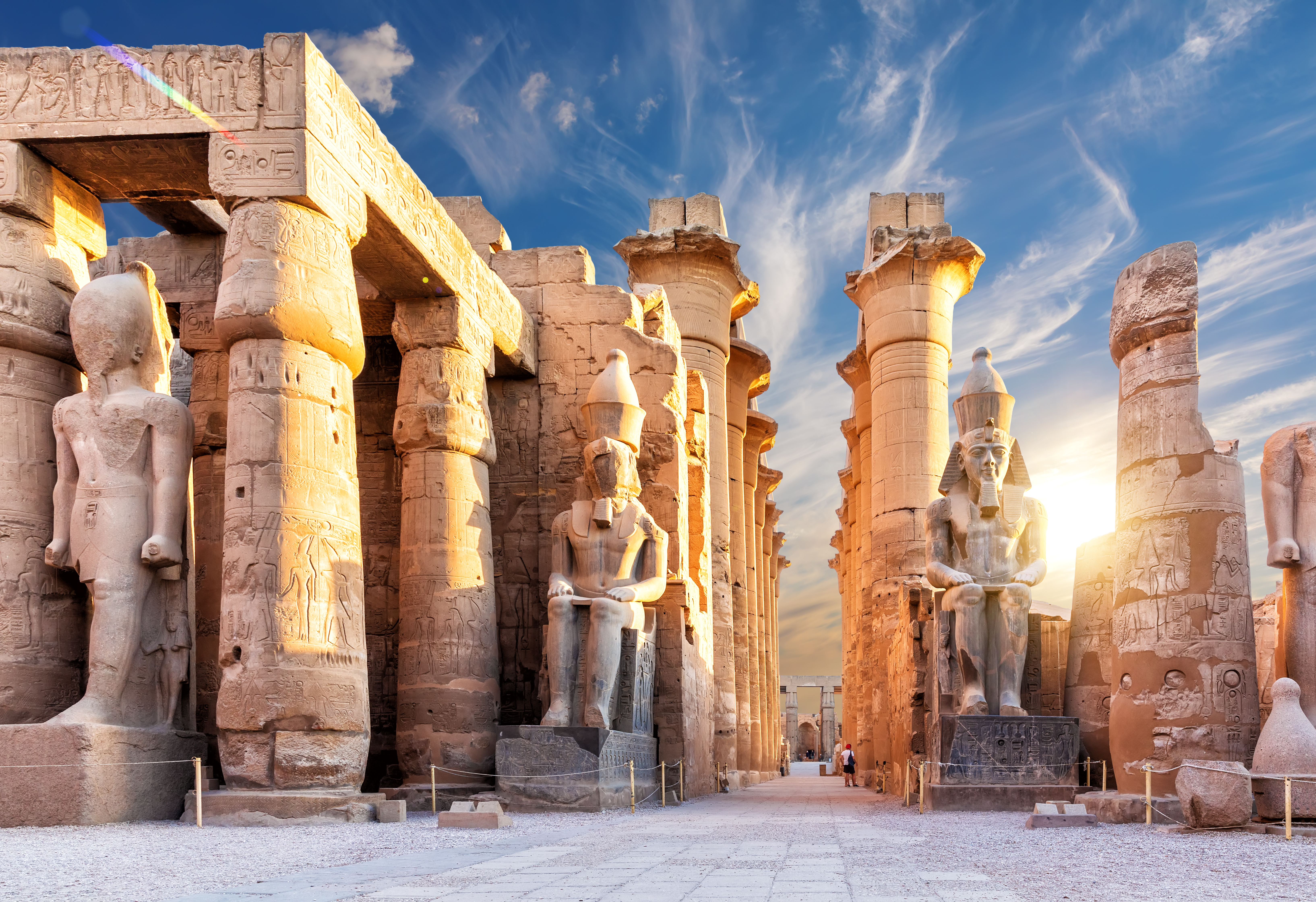 Majestætiske søjler og farao-statuer ved indgangen til Luxor Templet i Egypten ved solnedgang