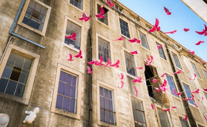 Charmerende pink bygning i LX Factory kunstkvarteret i Lissabon med traditionel portugisisk arkitektur og balkoner