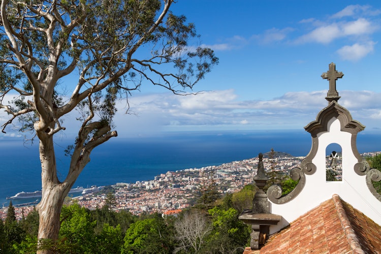 Panoramaudsigt over Funchal på Madeira med traditionelt portugisisk kirketårn og Atlanterhavet fra bjergtoppen
